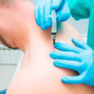 Paciente masculino recibiendo una expulsión en la parte posterior de su hombro por un profesional médico