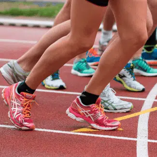 Grupo de personas haciendo cola para correr en una pista roja