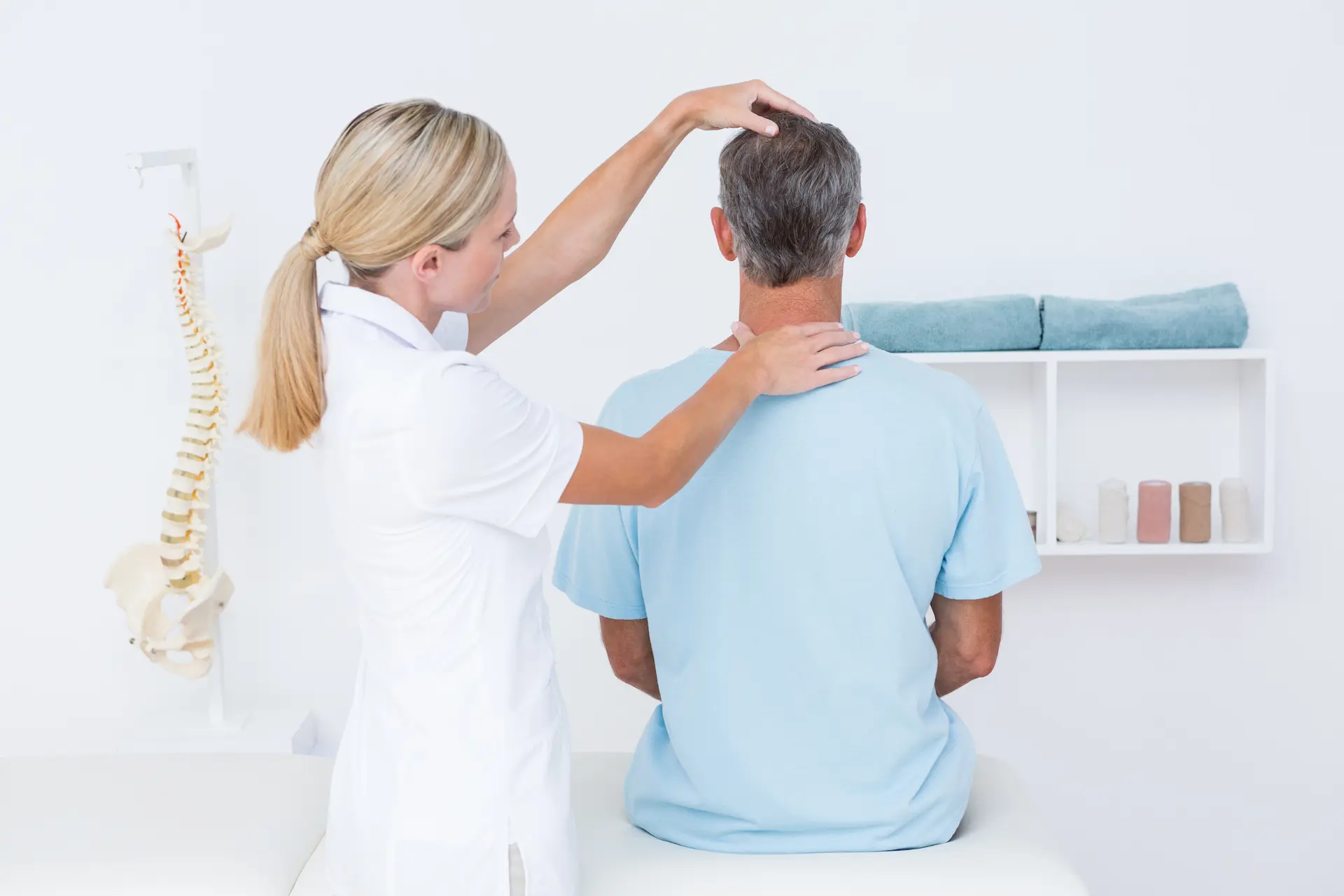 Medical provider examining male patient's neck