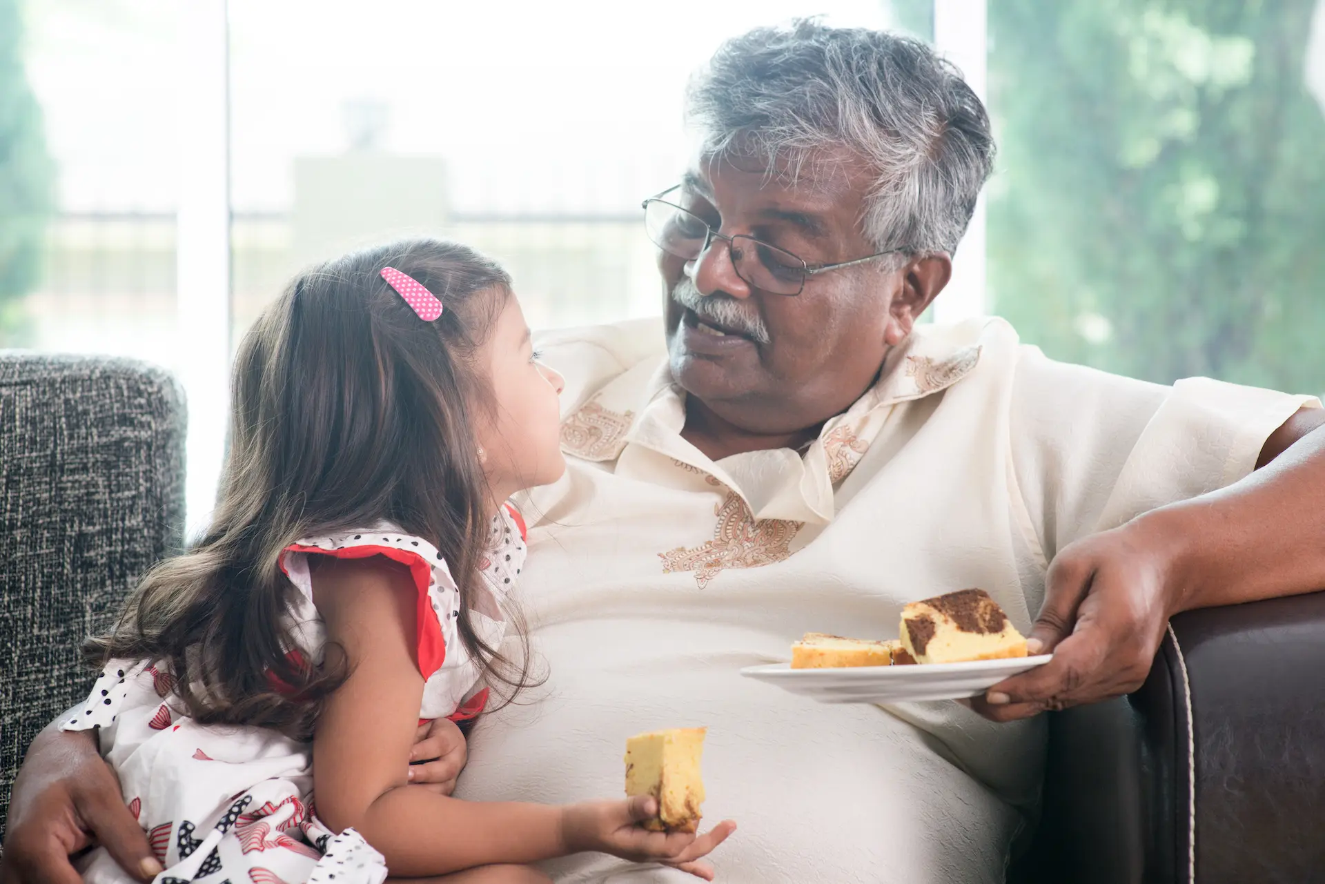 Grandfather and granddaughter eat cake