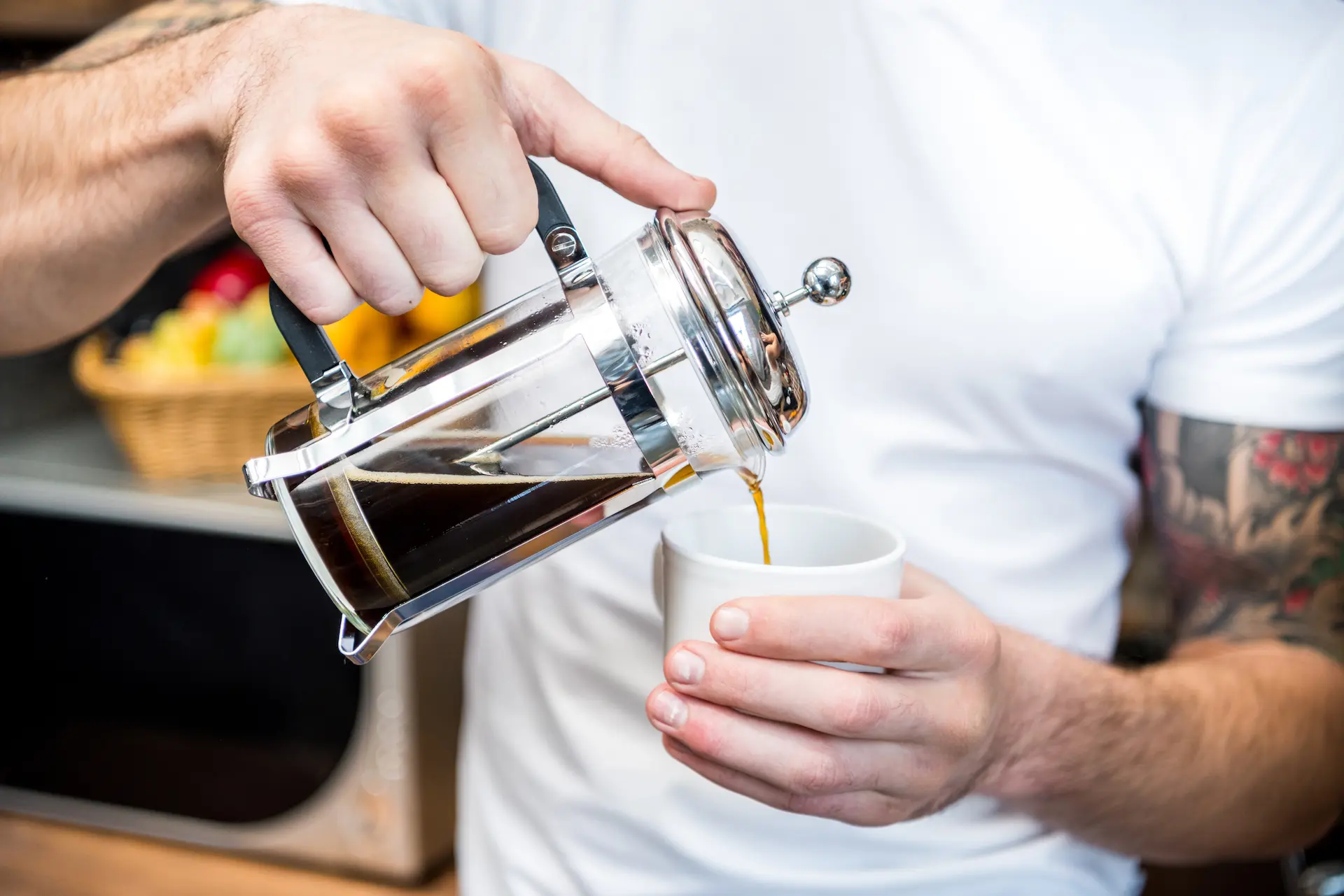 a man pours coffee for himself from a french press