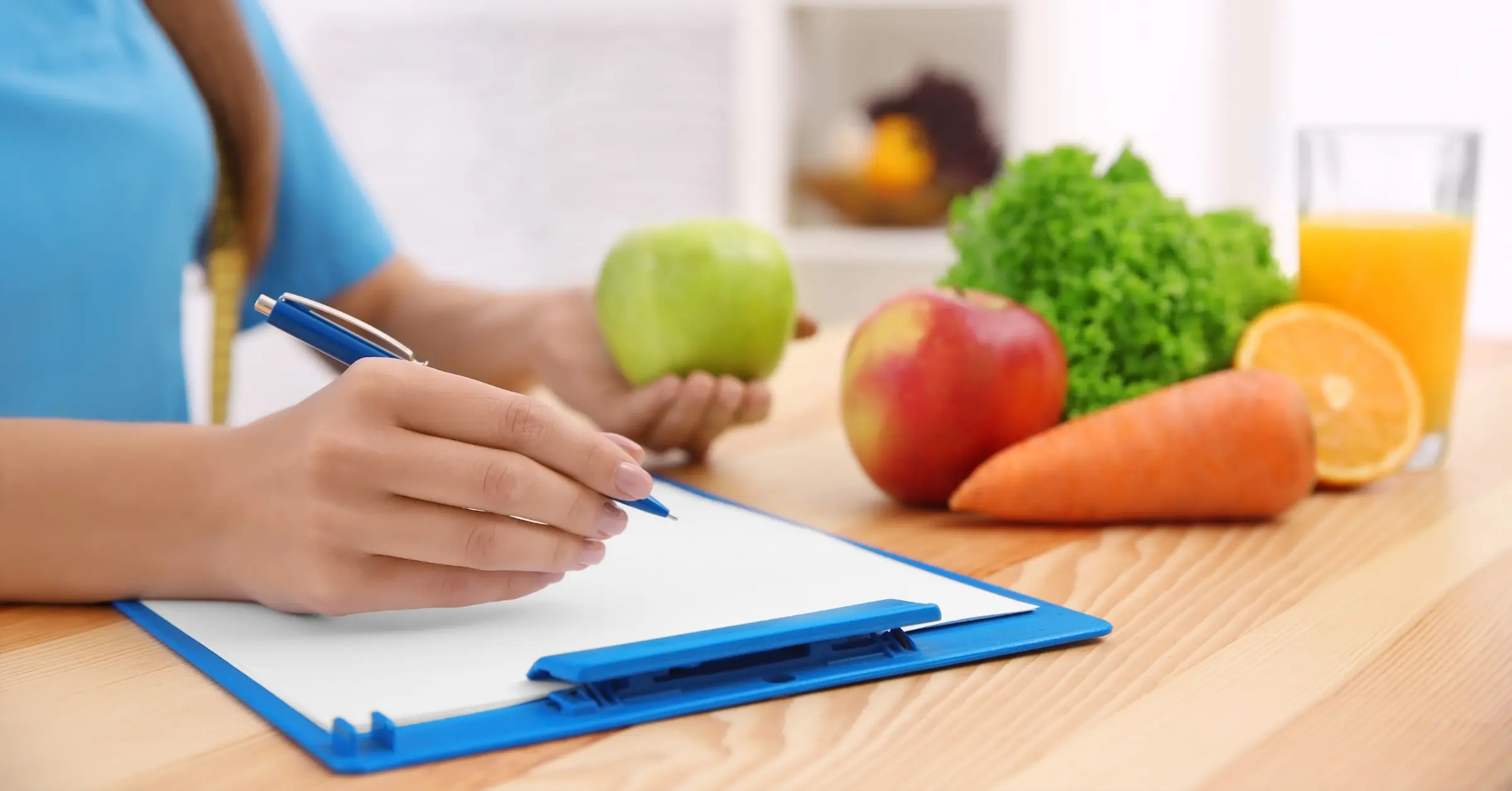 a nutritionist writes on a clipboard