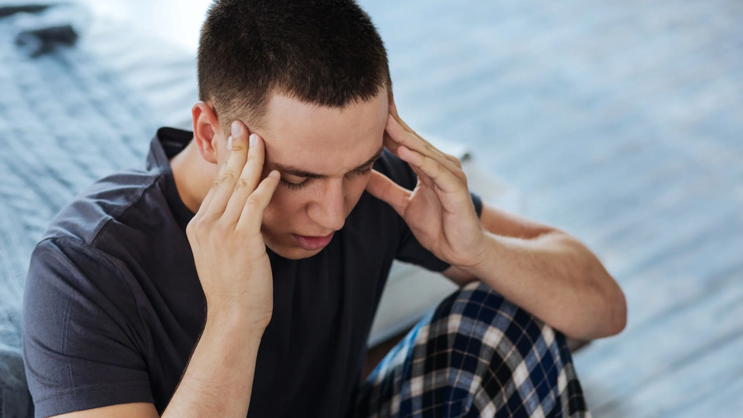 Male holding temples in pain