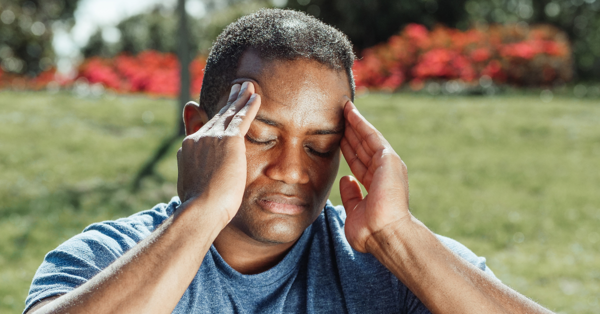 person holding their head with headache pain