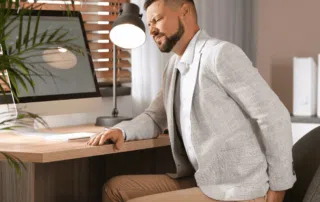 man at desk with sciatic pain