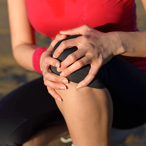 Woman holding knee in pain