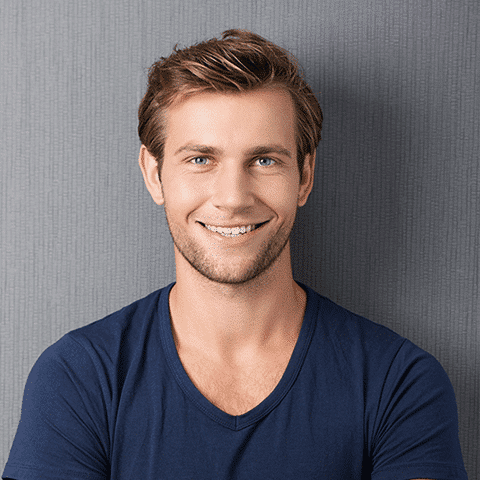 young man in navy blue leaning on gray wall