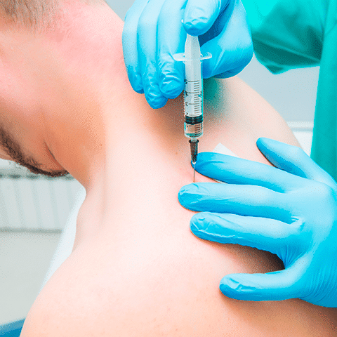 Male patient receiving trigger point injection in back of shoulder