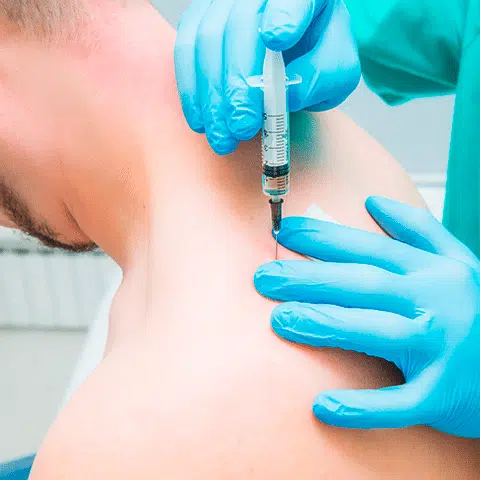 Male patient getting an ejection in the back of his shoulder by a medical professional