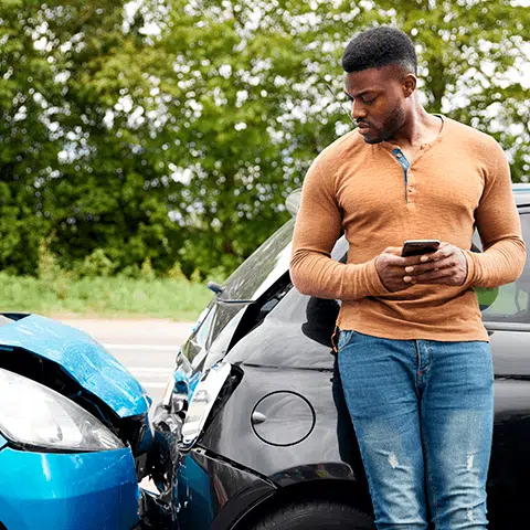 Man leaning on his car after getting in an accident