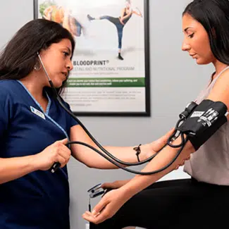 Woman getting blood pressure taken by a medical professional