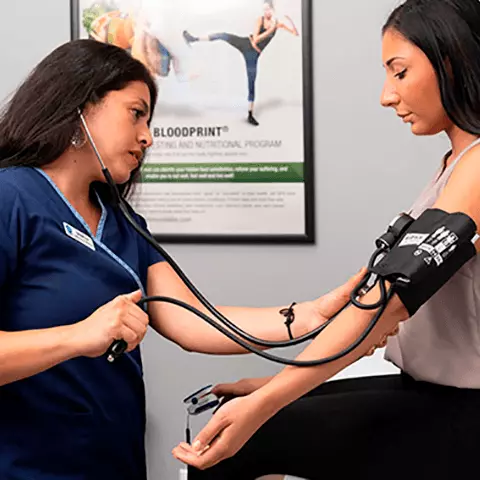 Woman getting blood pressure taken by a medical professional