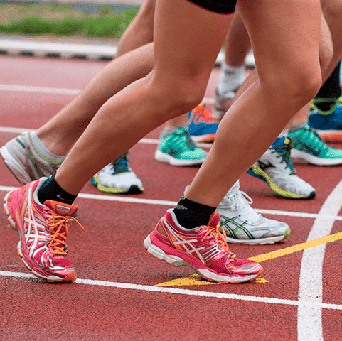 Group of people lining up to race on a red track