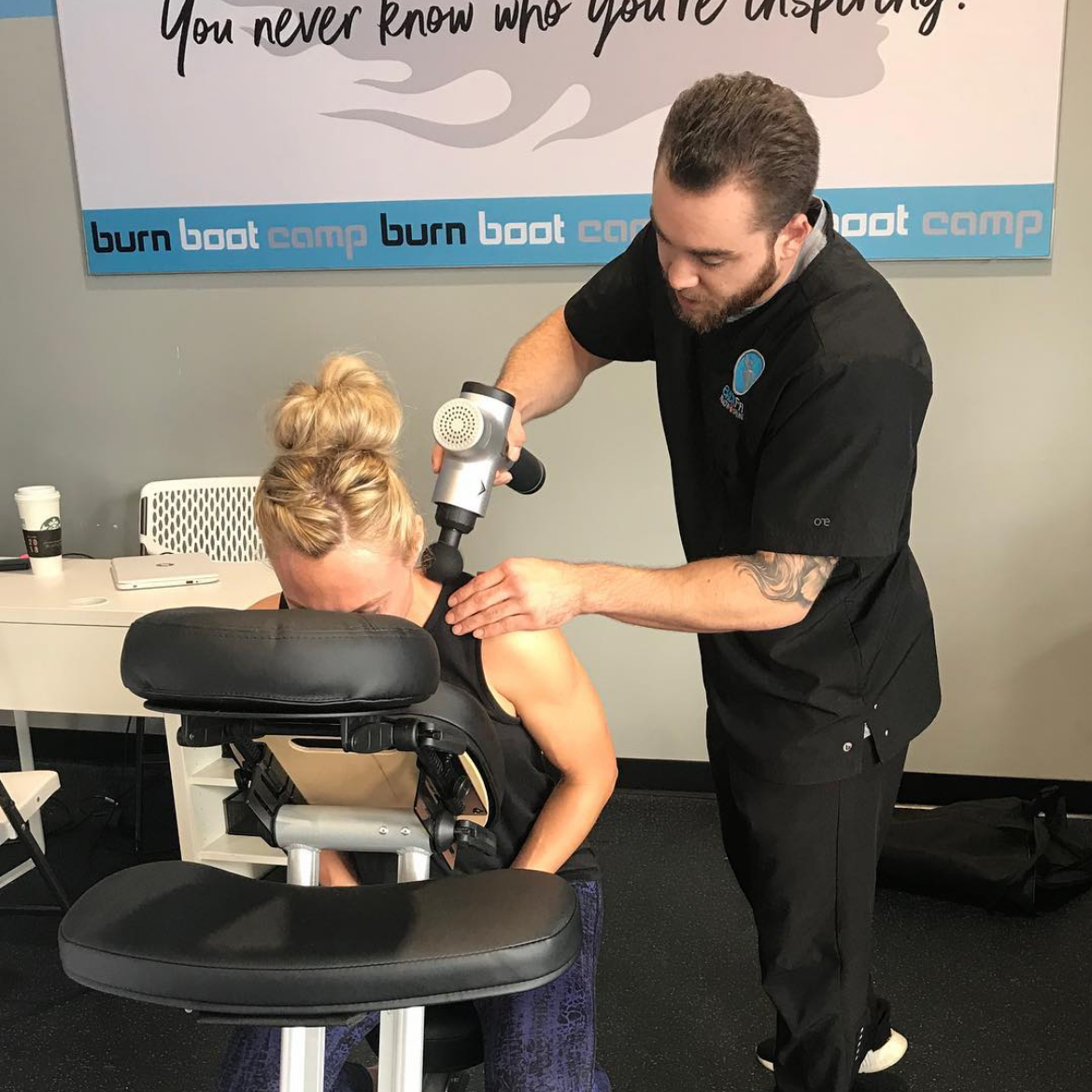 Tech massaging a woman in a massage chair