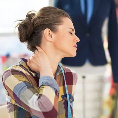 Mujer sujetando su cuello con dolor